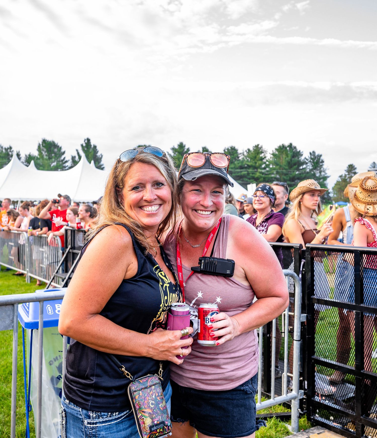 Friends enjoying drinks and laughter at an outdoor summer festival.