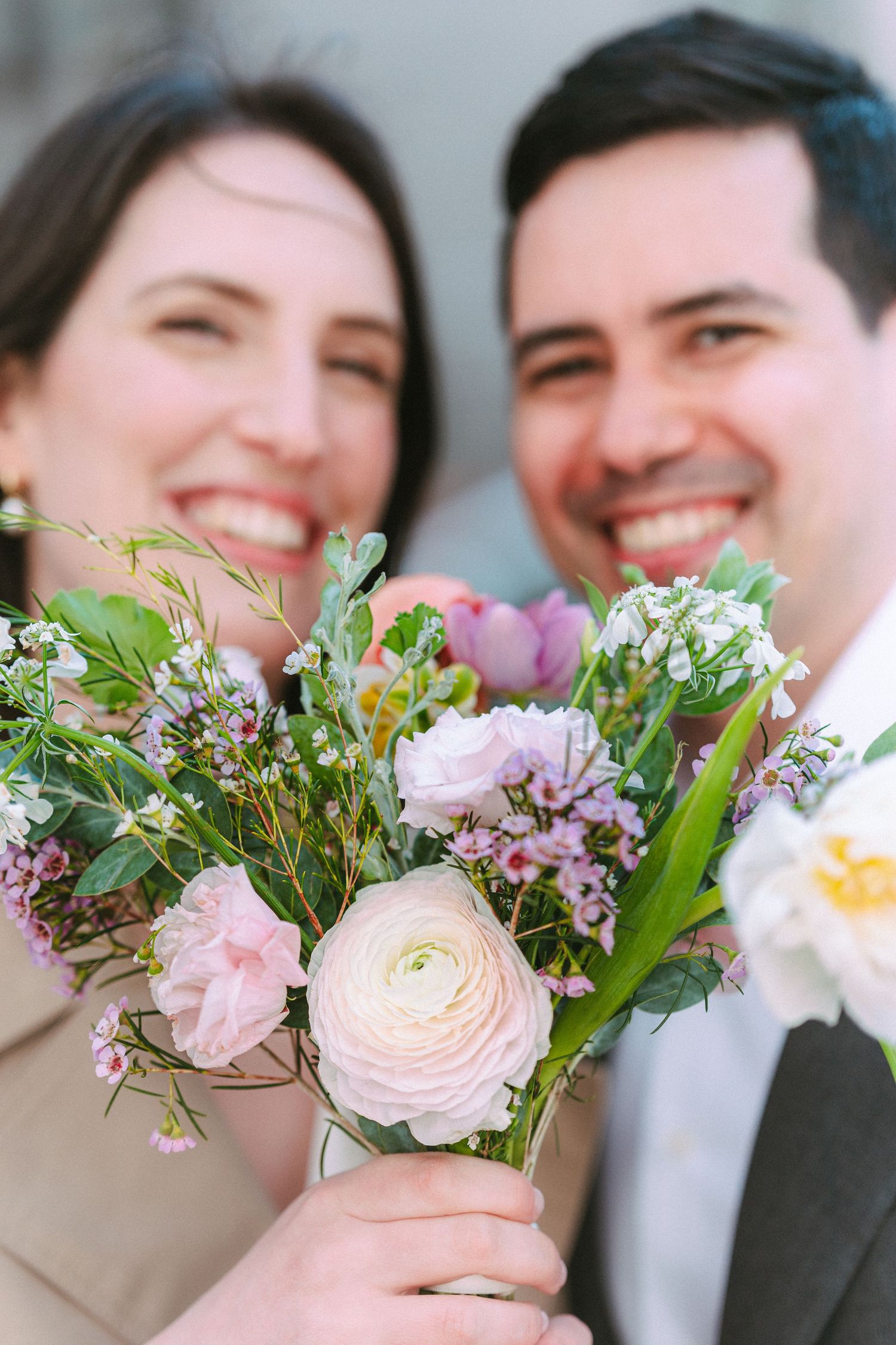 Just married couple holding a bouquet of flowers