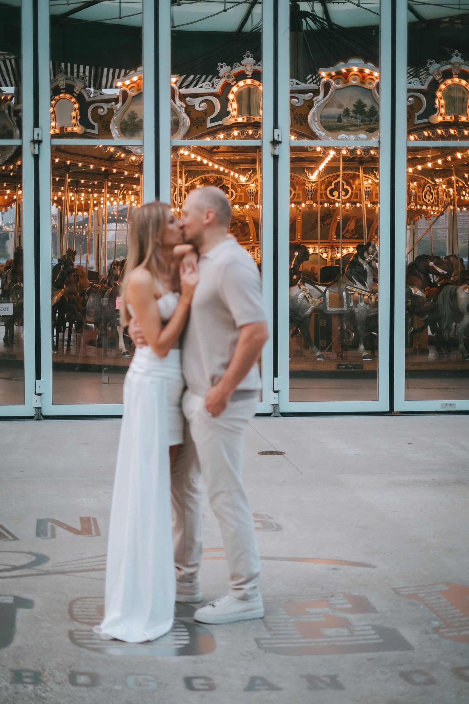 A couple kissing in front of Jane's Carousel in DUMBO, Brooklyn