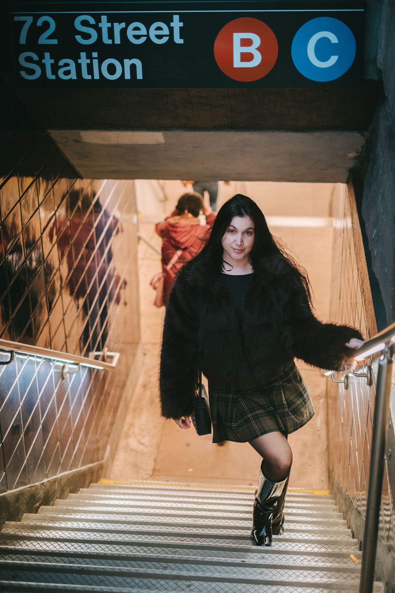 Woman posing on the stairs of a subway station in New York City