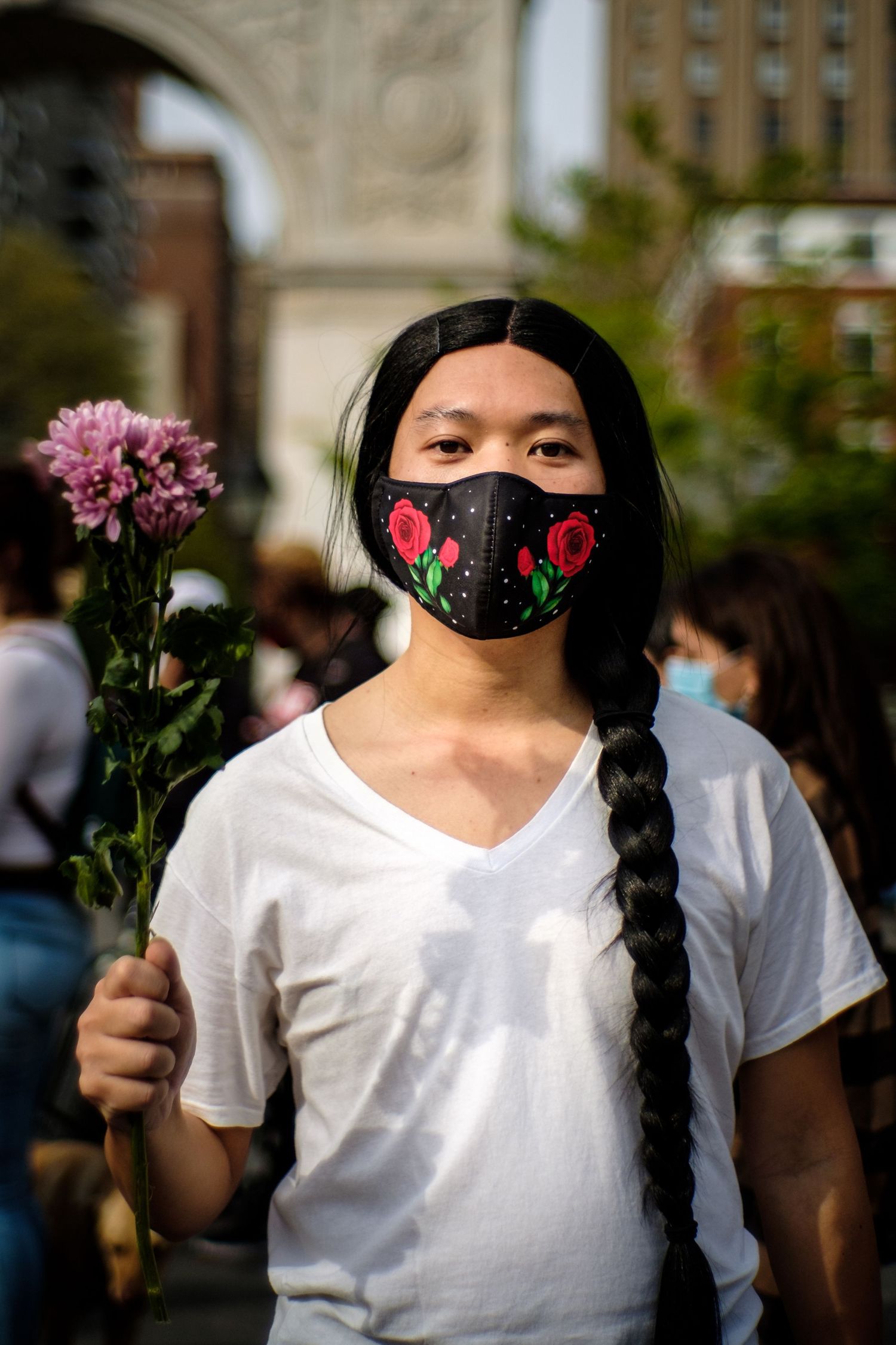Asian man holding a flower in remembrance of victims of police brutality