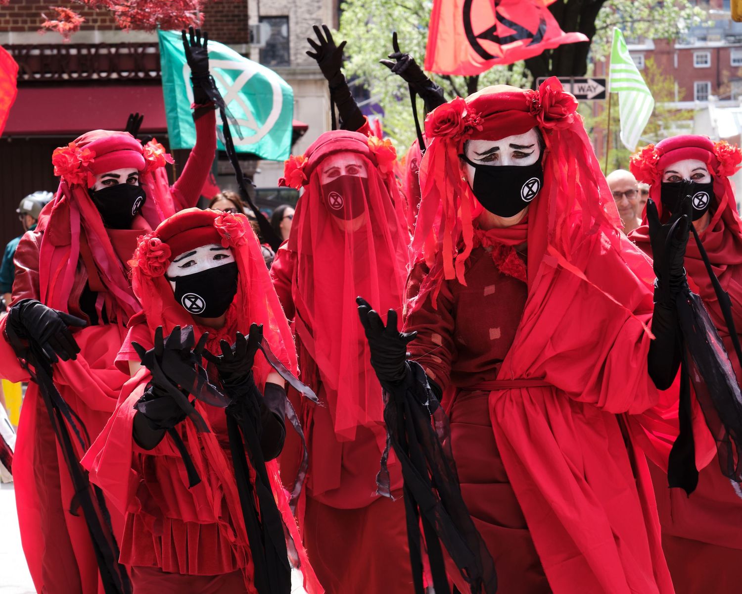 Climate protestor dressed in red performing against fossil fuels