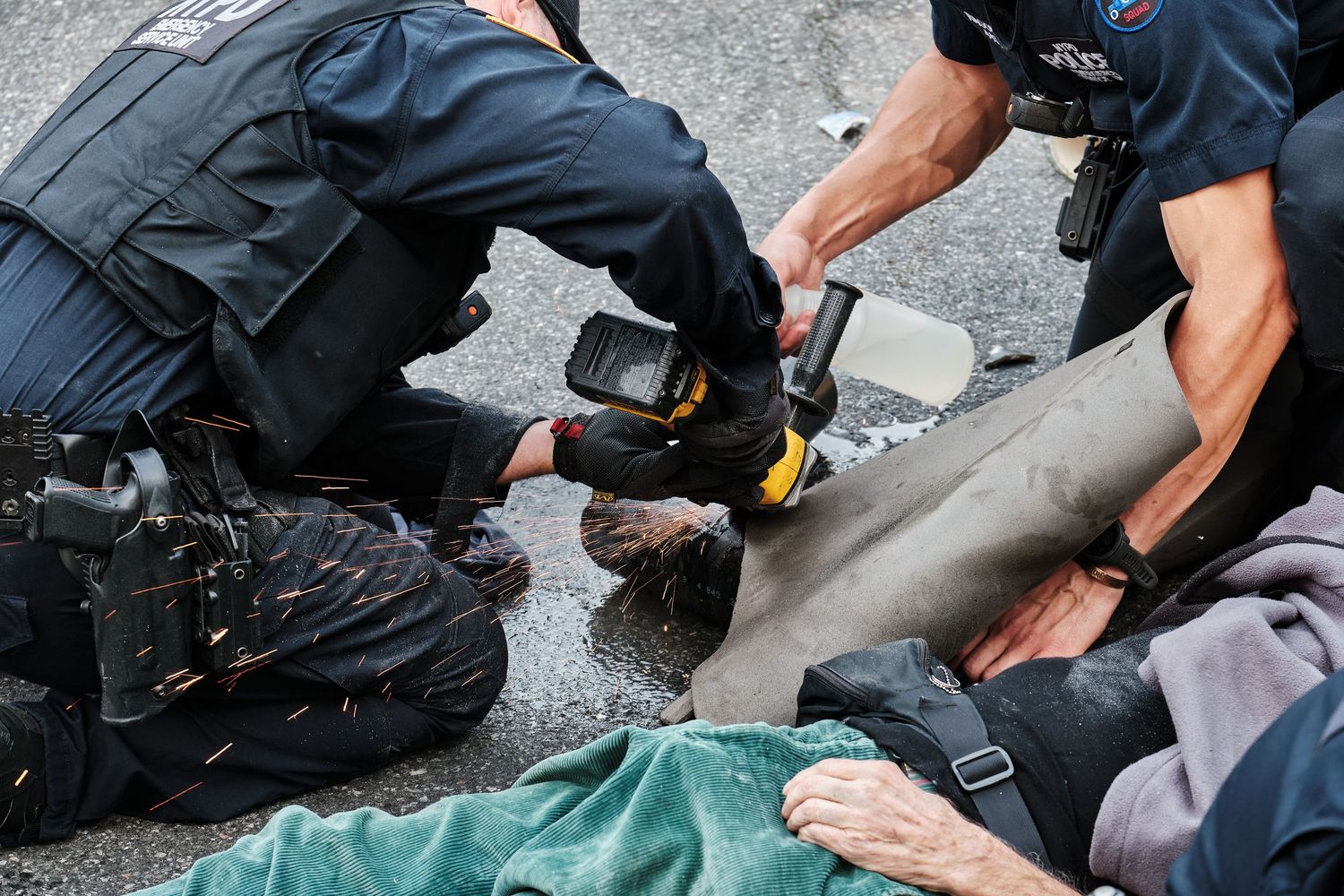 Police removing shackles from a climate protestor