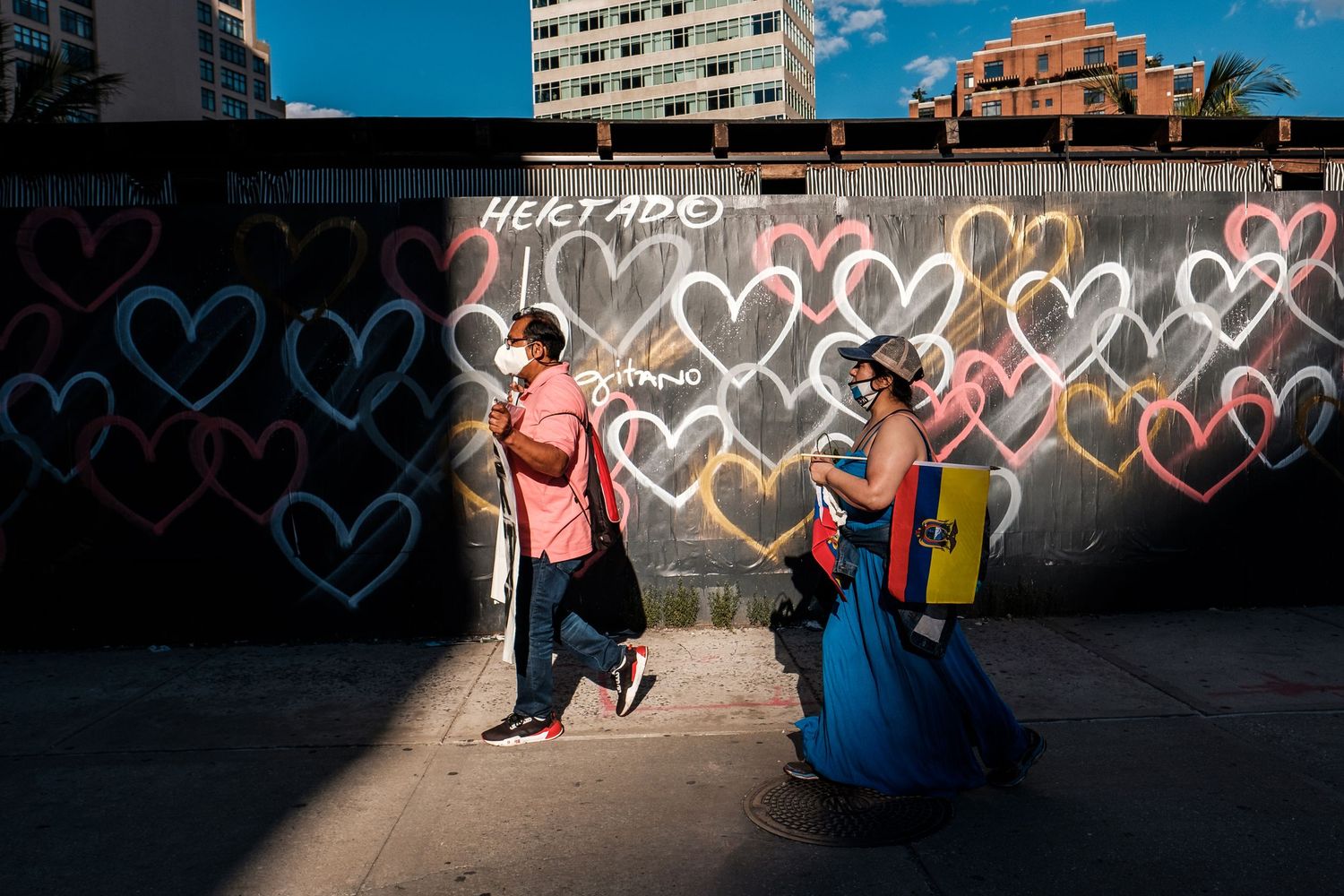 Climate activists marching in Manhattan past a colorful wall of hearts