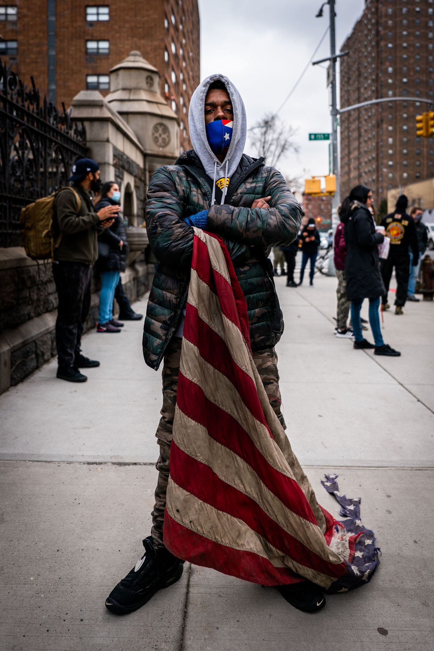 Black man carrying worn American flag in protest
