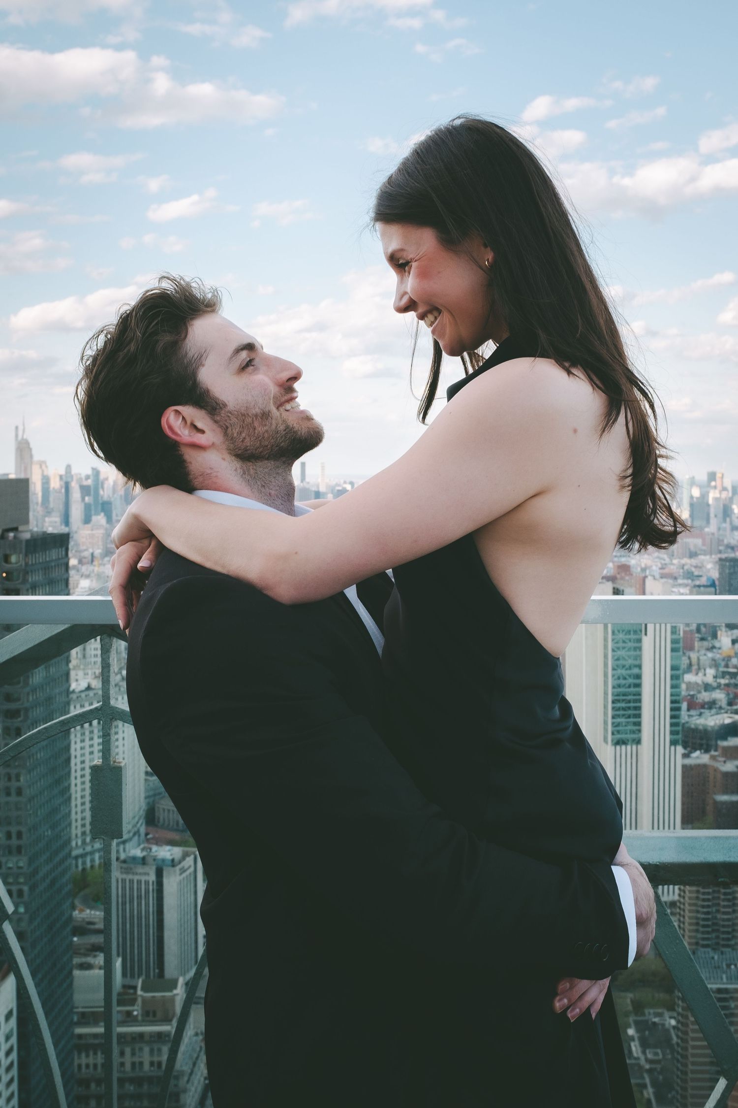 A man lifting his fiancee in the air to celebrate their engagement