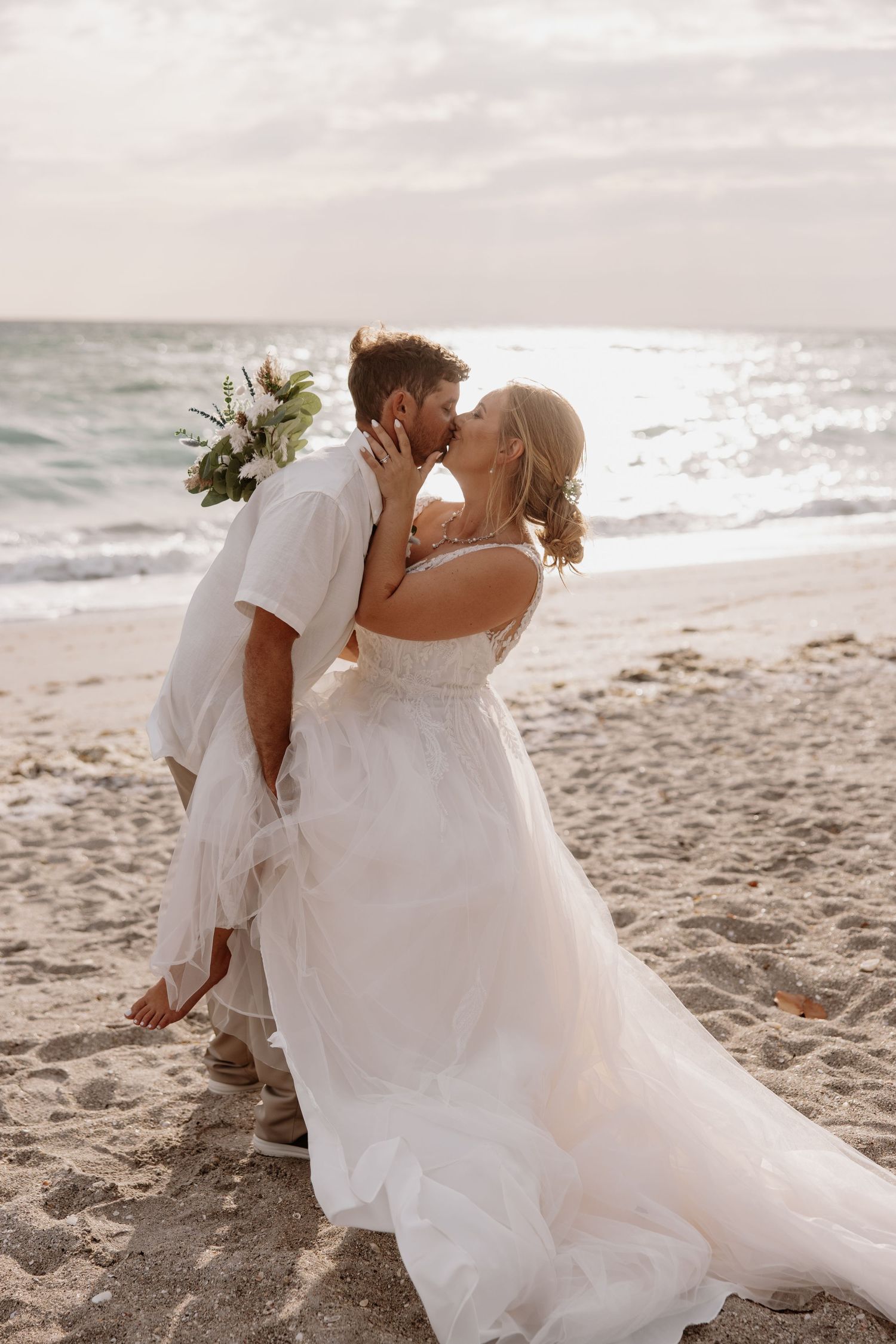 A couple shares intimate moments during their beach wedding photoshoot at sunset.