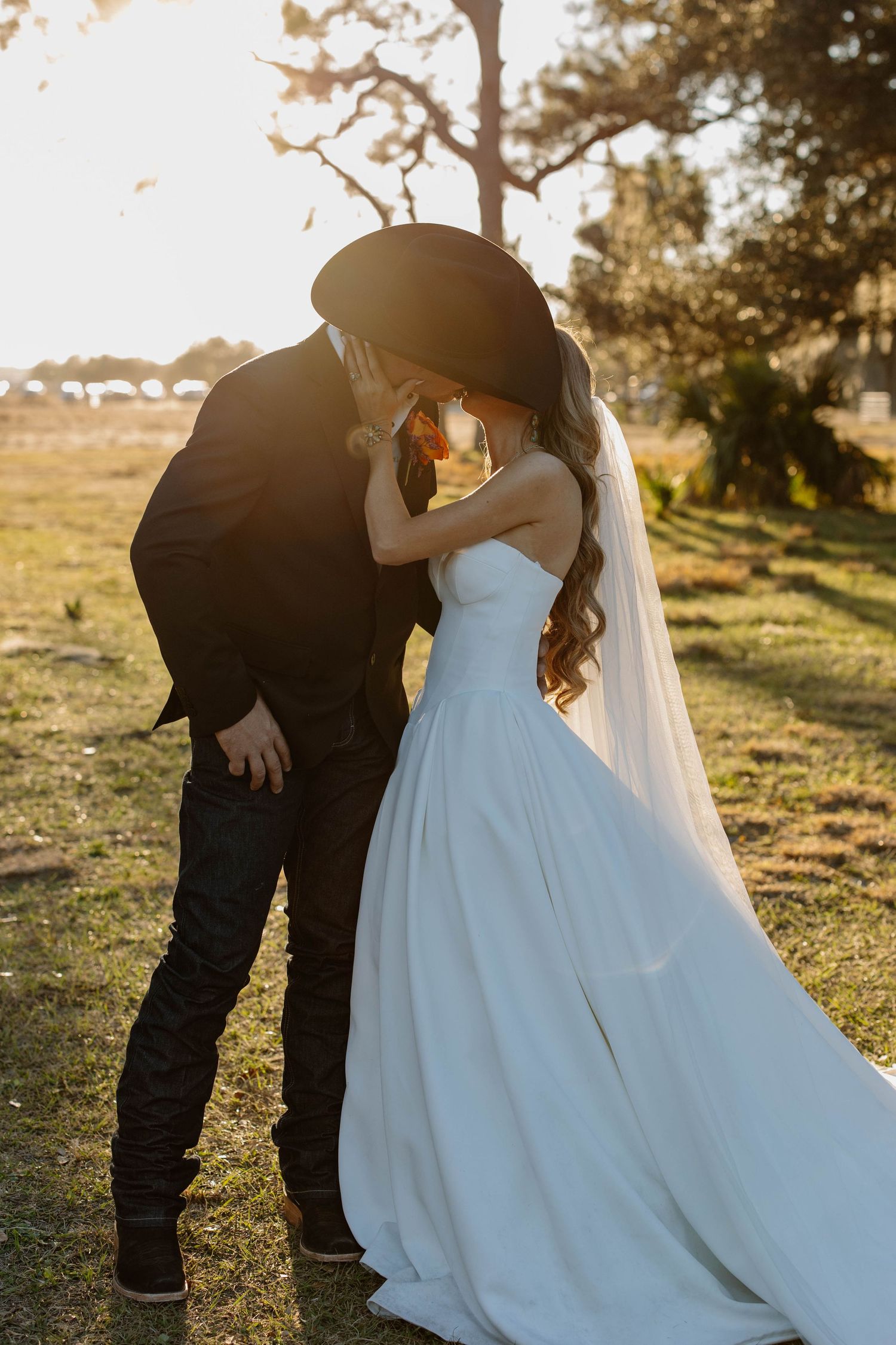 Romantic sunset wedding portraits with couple in white gown and black suit.