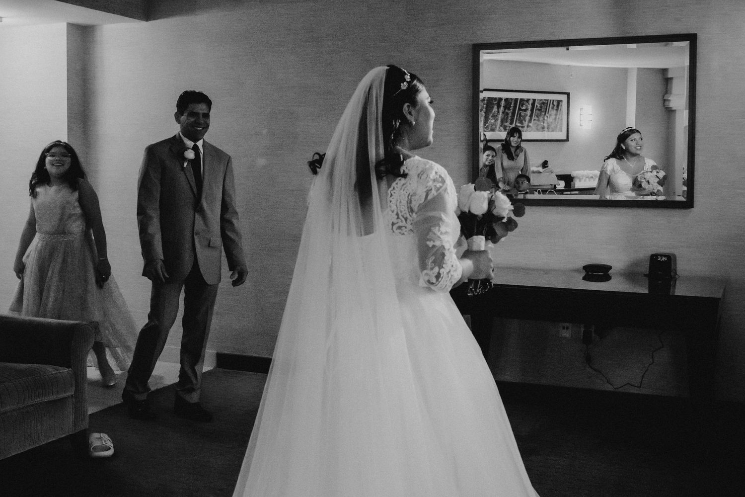 A black and white photo sequence showing a bride and groom's first look moment in an intimate indoor setting.