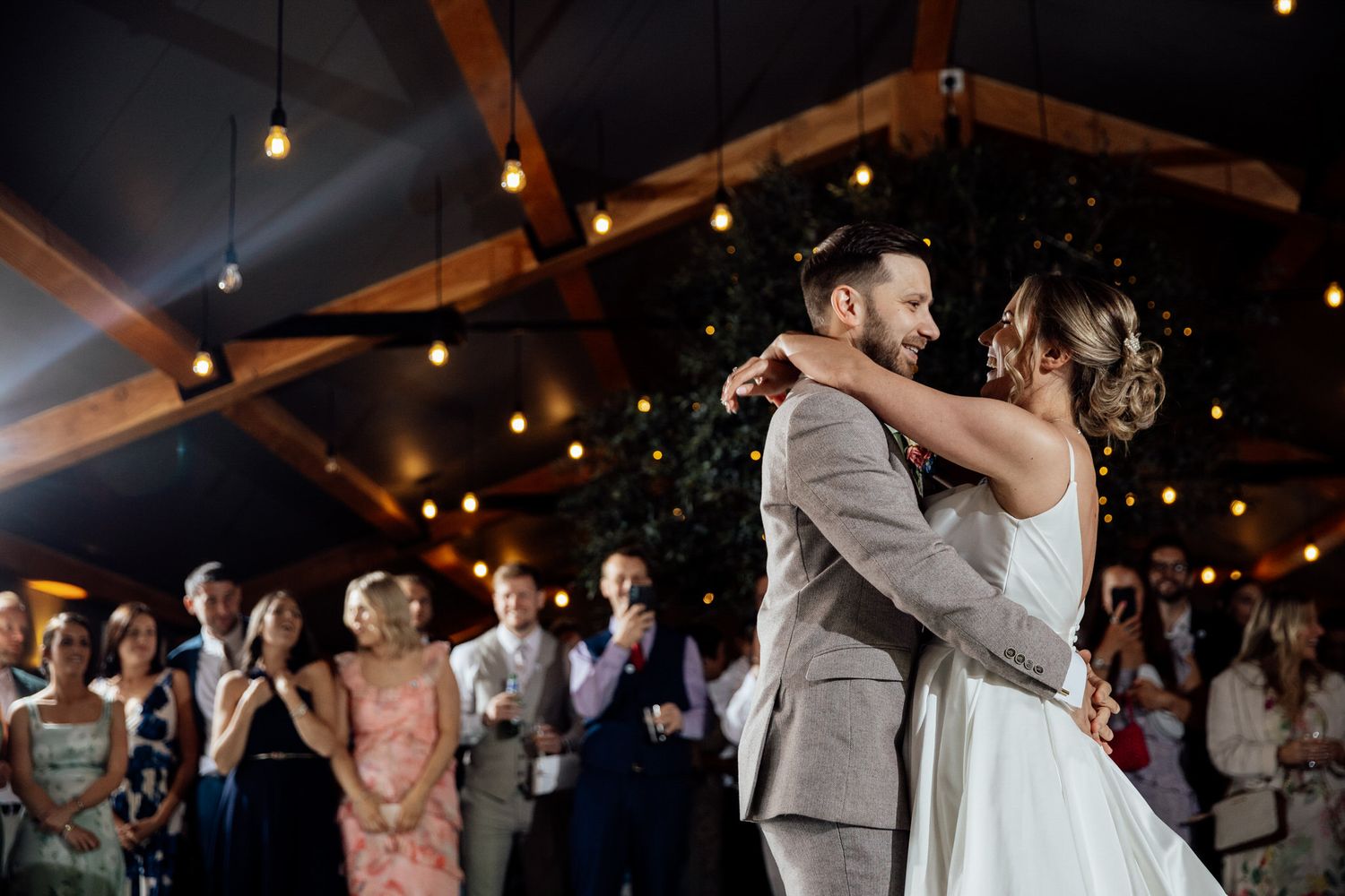 Evening wedding reception with couples dancing under ambient lighting.