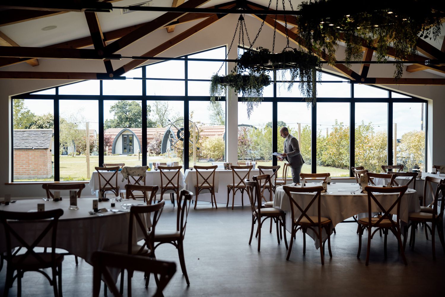 A modern reception venue with cross-back chairs and large windows overlooking scenic views.