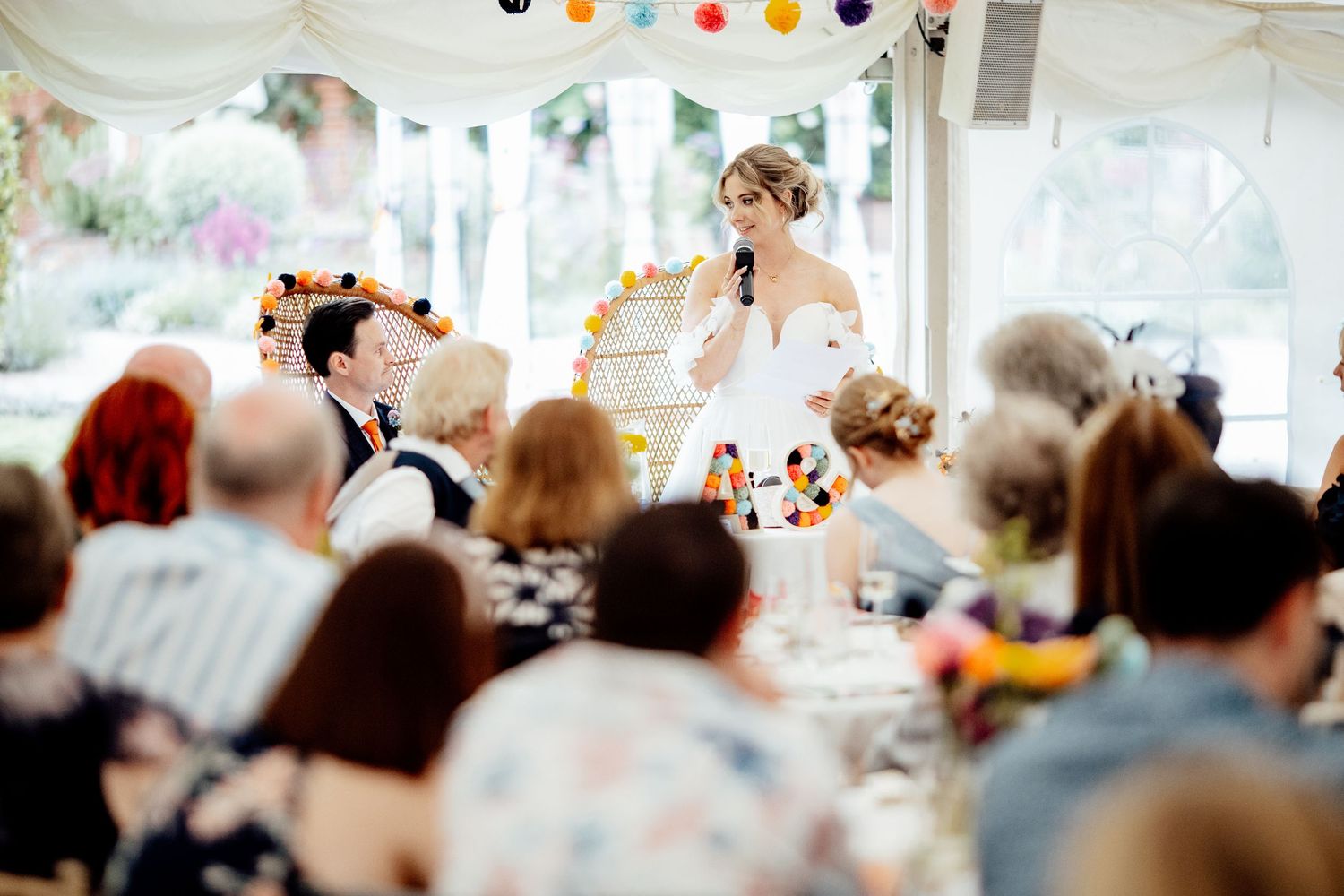 Wedding guests enjoy a lively outdoor reception with string lights and decorations.