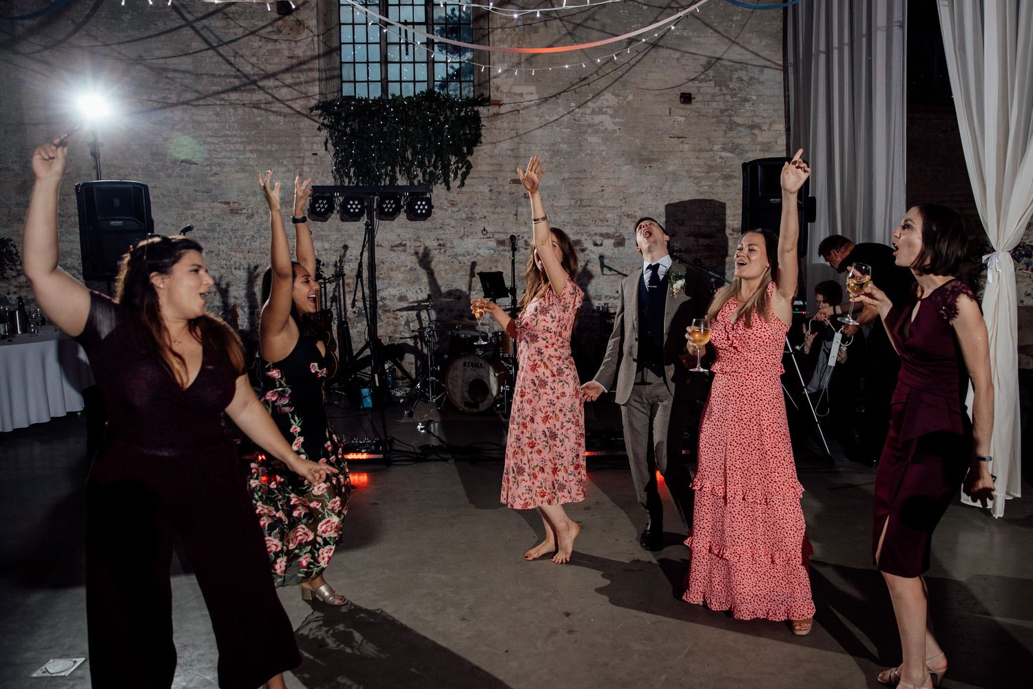 Wedding reception dance floor with guests dancing in formal attire.