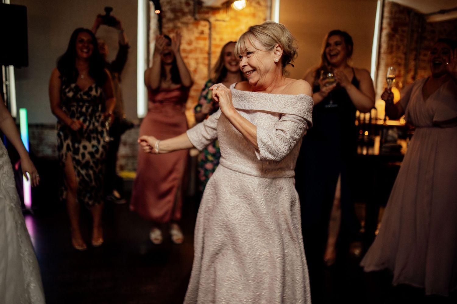 Couples dancing together during an evening wedding reception.
