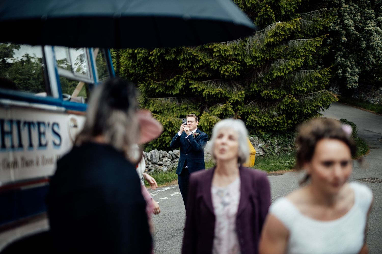 A couple celebrates their wedding day outside a rustic stone building with festive decorations.