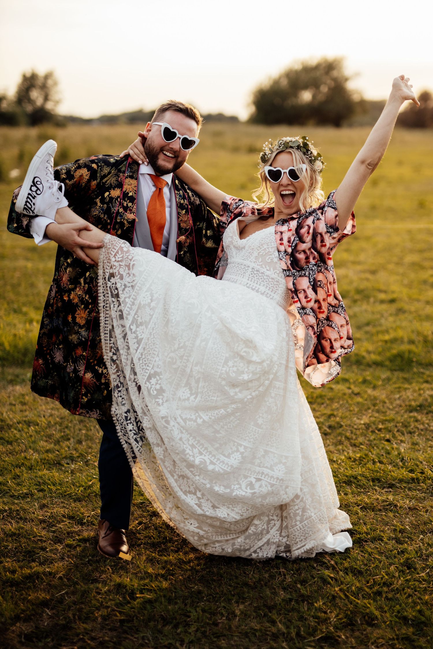 A playful wedding photo sequence showing a couple dipping in a grassy field at sunset.