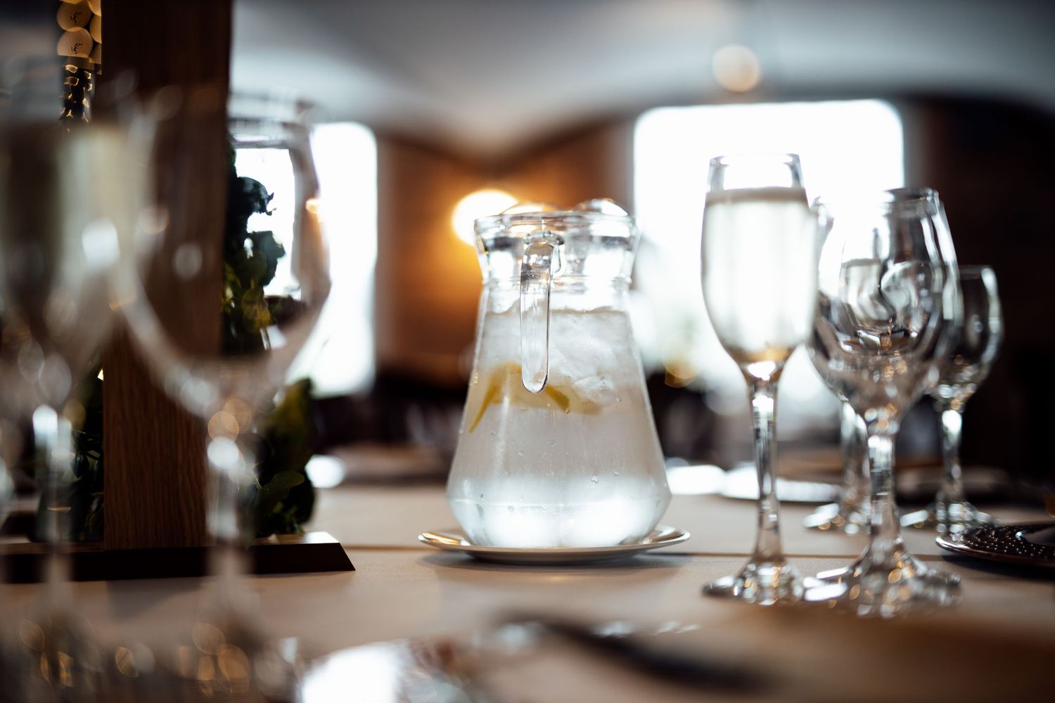 Elegant place settings with wine glasses and table decor at a wedding reception.