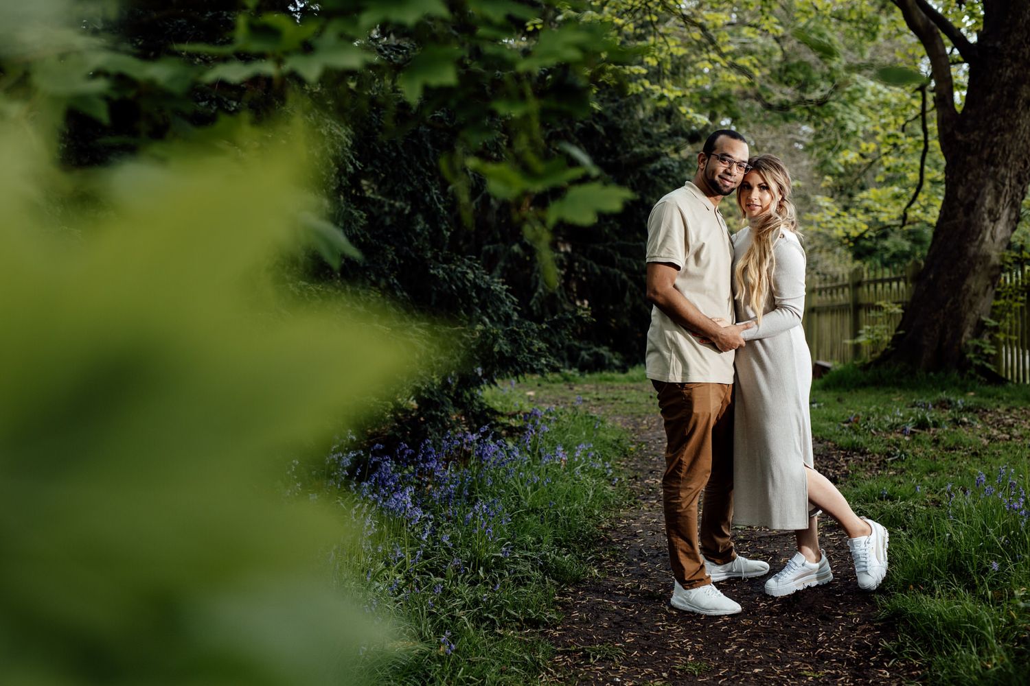 Romantic outdoor photoshoot in a lush green garden setting with natural lighting.