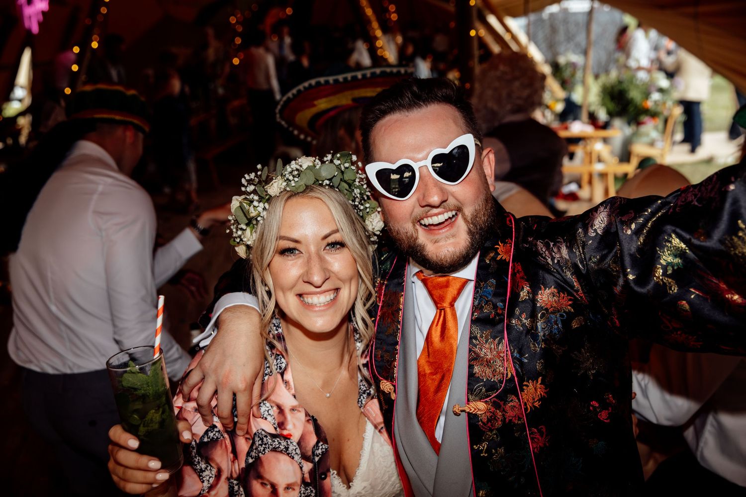 A festive wedding celebration with colorful floral decorations and sunglasses.