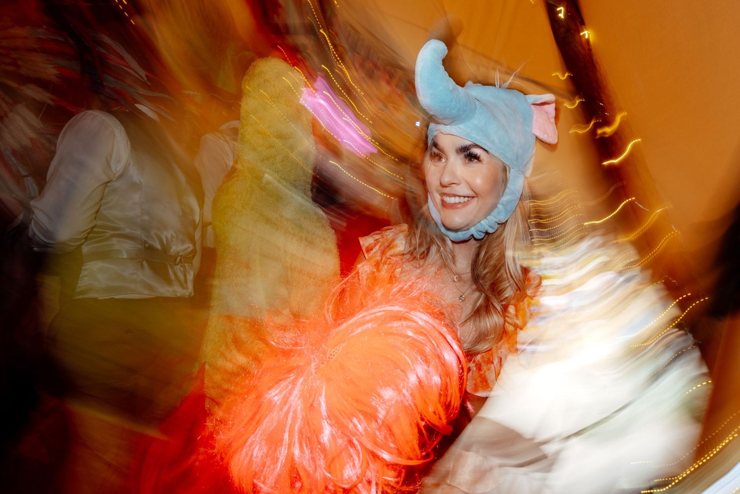 Motion-blurred dance photo with colorful lighting effects at wedding reception.