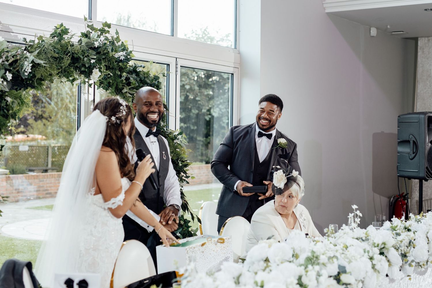 Elegant wedding reception setup with white floral centerpieces and natural lighting.