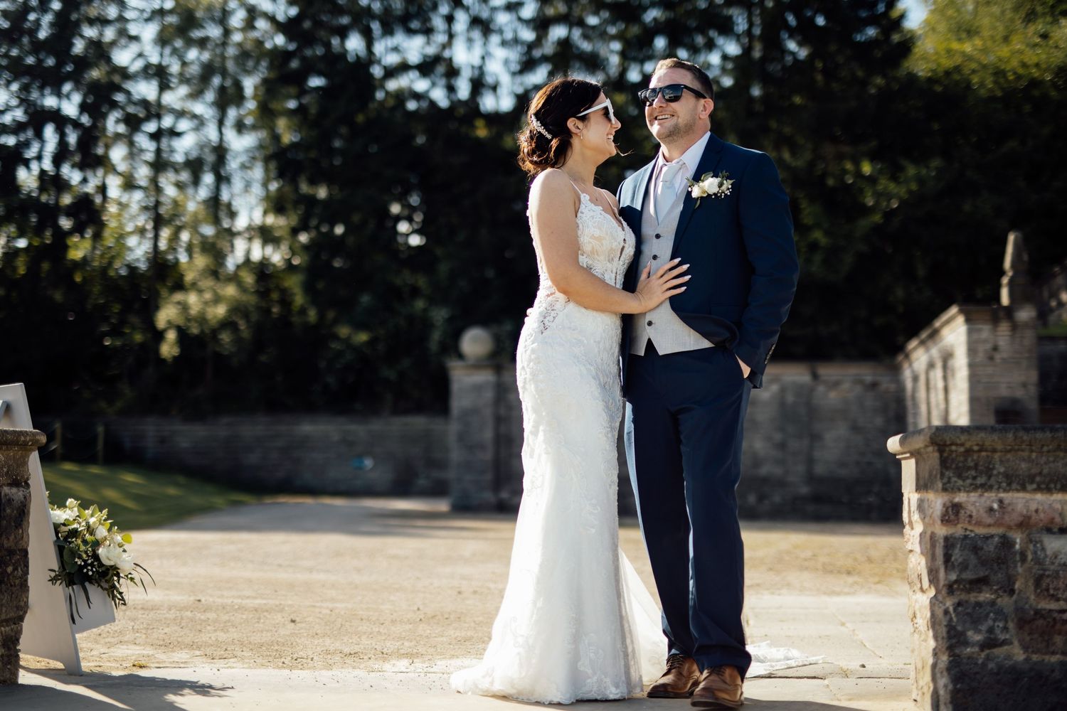 Wedding couple poses for portraits in an outdoor garden setting.