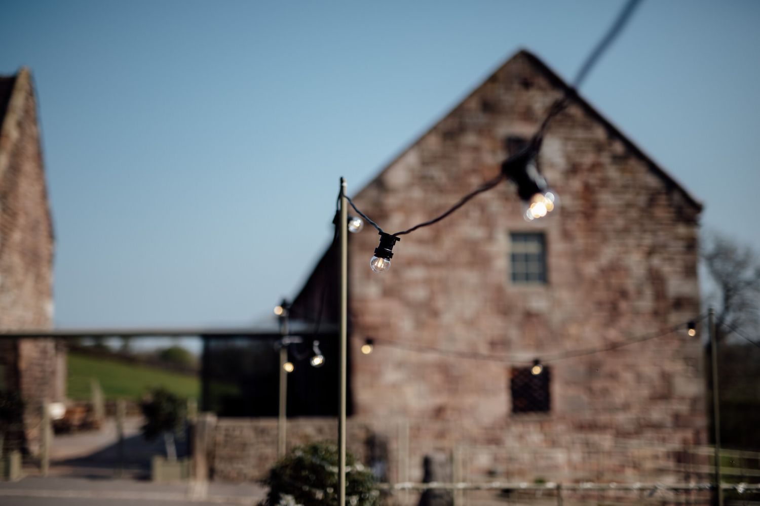 Stone buildings photographed against blue sky in rustic setting.