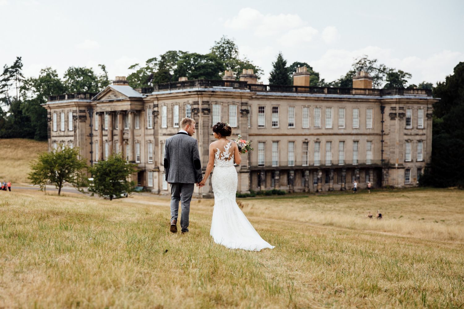 Wedding photos taken in front of a grand historic mansion with manicured grounds.