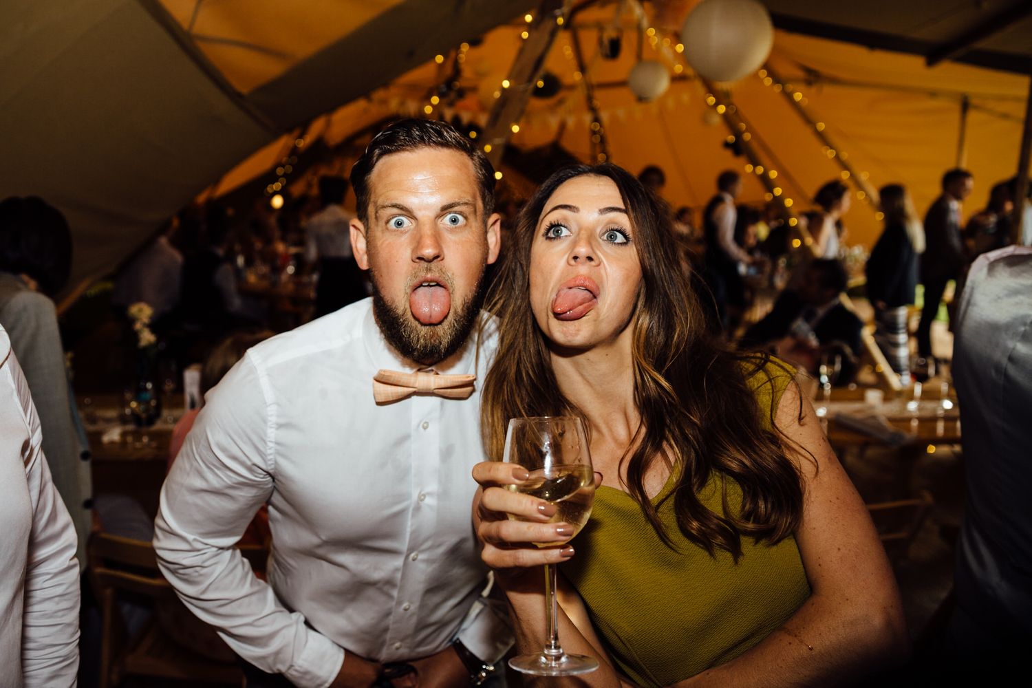 Wedding party guests dancing and celebrating at a lively tipi reception.