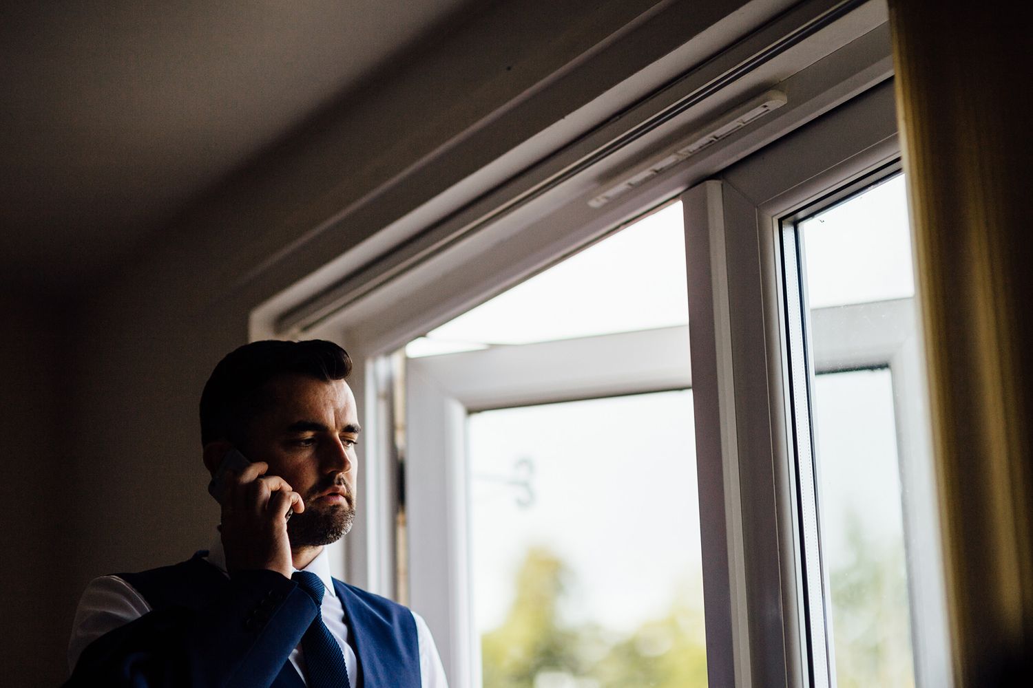 Wedding preparations in a bright sunlit room with elegant window views.