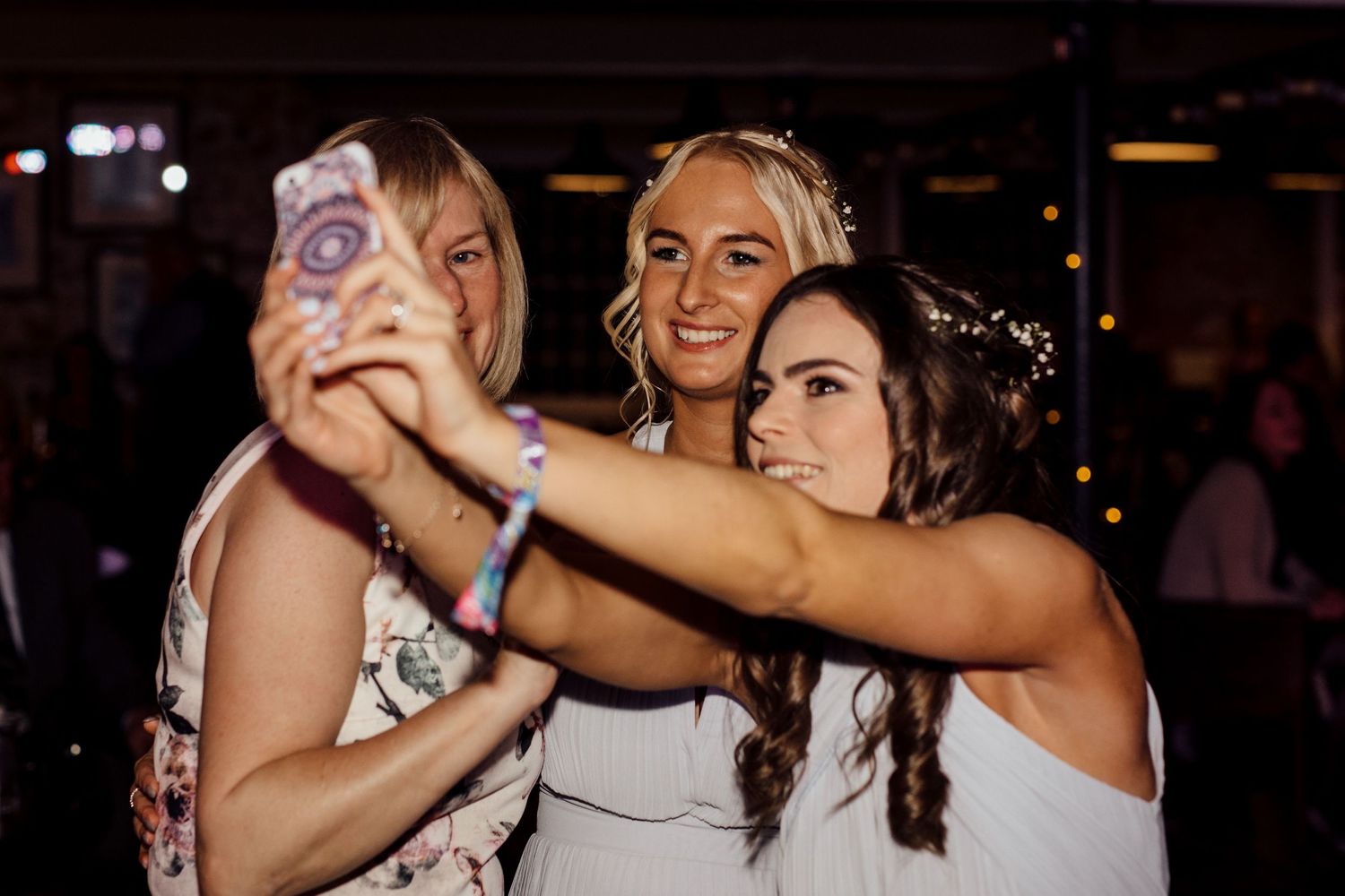 Wedding party dancing and having fun during evening reception celebrations.