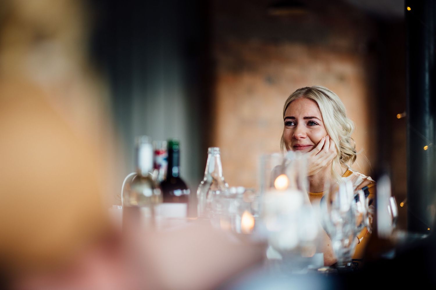 Wedding reception table settings with glowing candles and wine glasses create an intimate atmosphere.