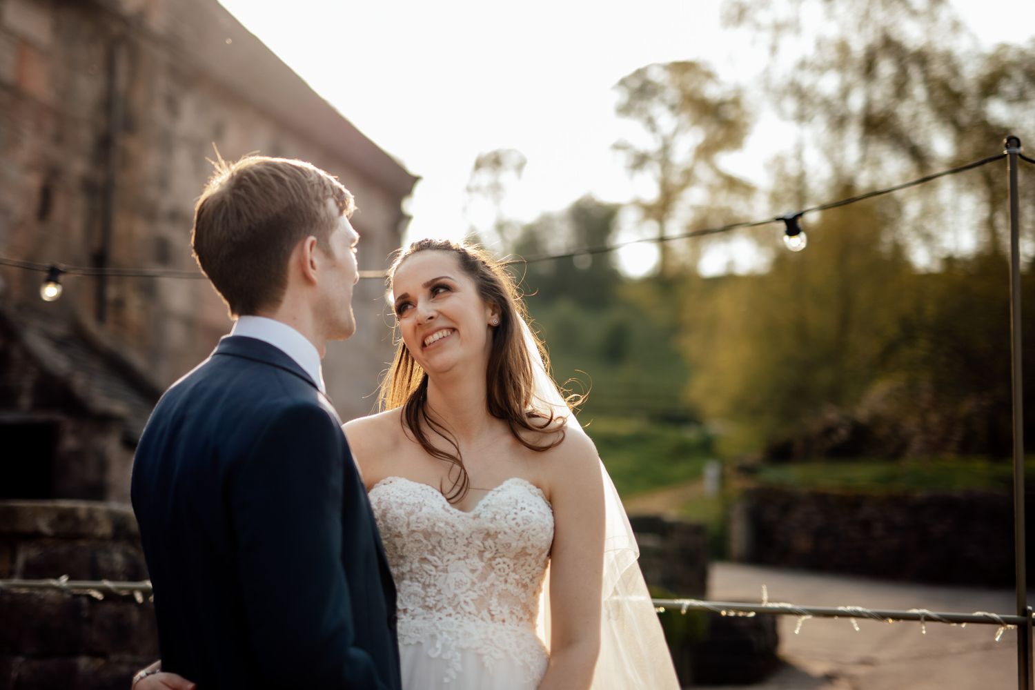 Romantic sunset wedding portraits captured against stone architecture and natural light.