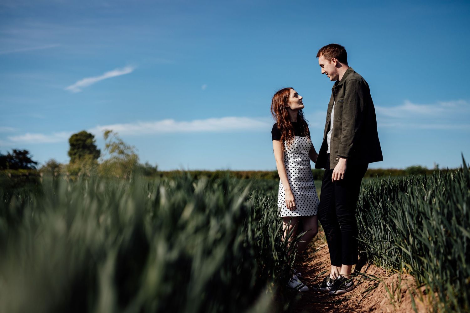 Couple enjoying a sunny afternoon among green wheat fields in the countryside.