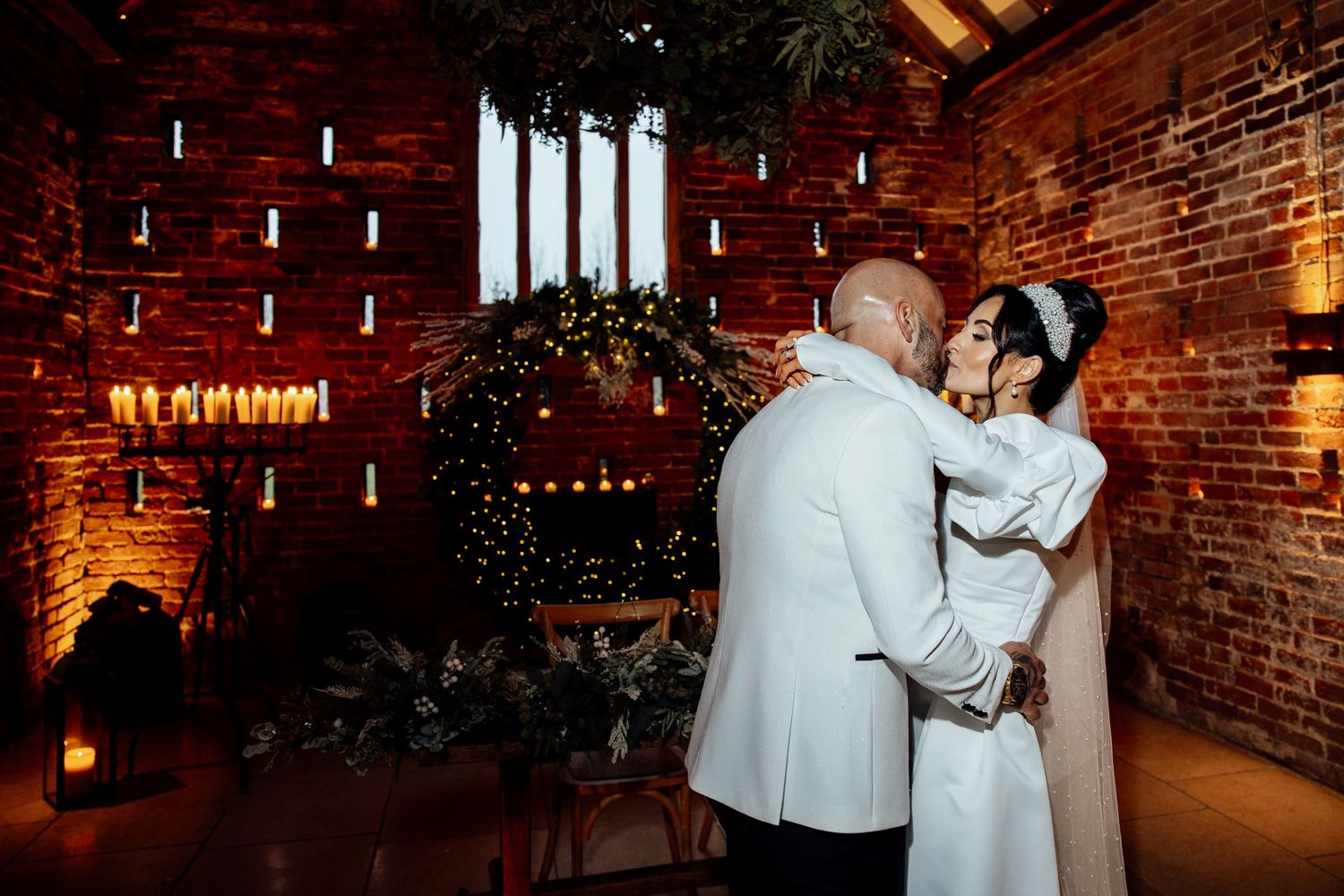 Romantic dance moves captured in a warmly lit brick-walled reception venue.