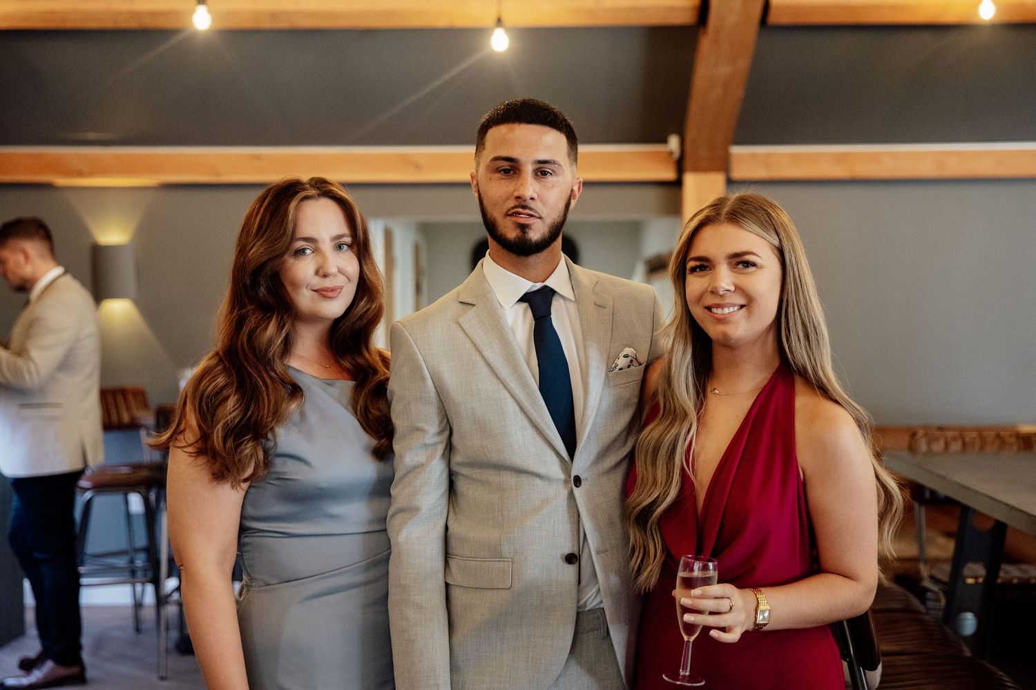 Wedding guests in formal attire mingle and socialize during an elegant reception celebration.