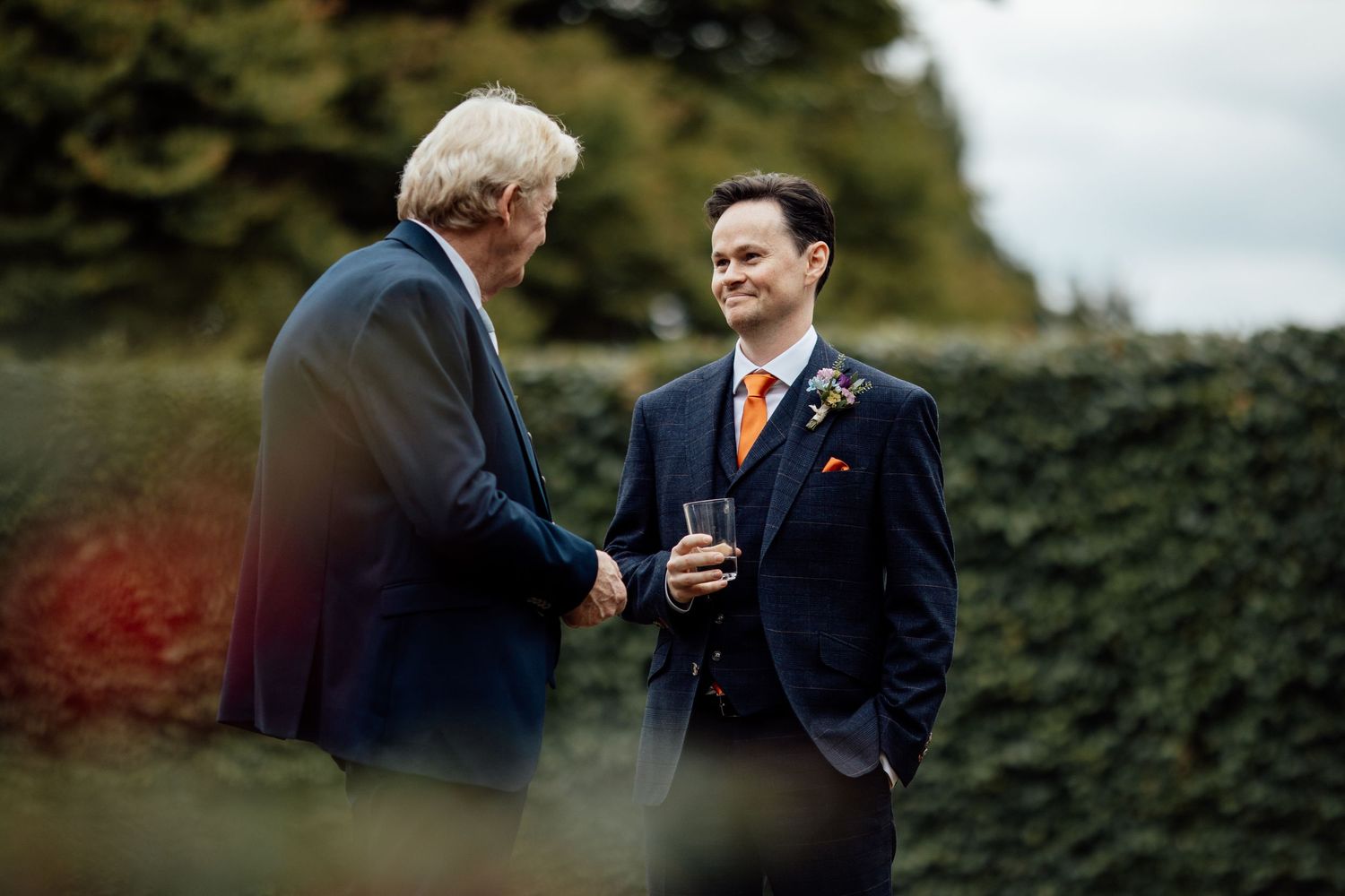 Wedding guests mingle and chat during an outdoor reception.