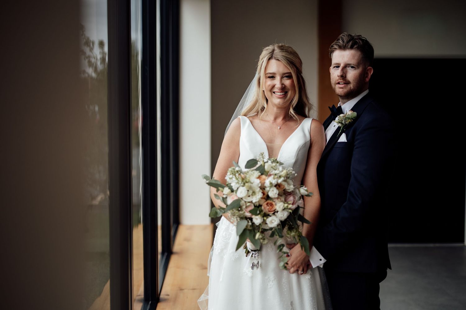 Romantic wedding portraits captured in a modern corridor with natural light.
