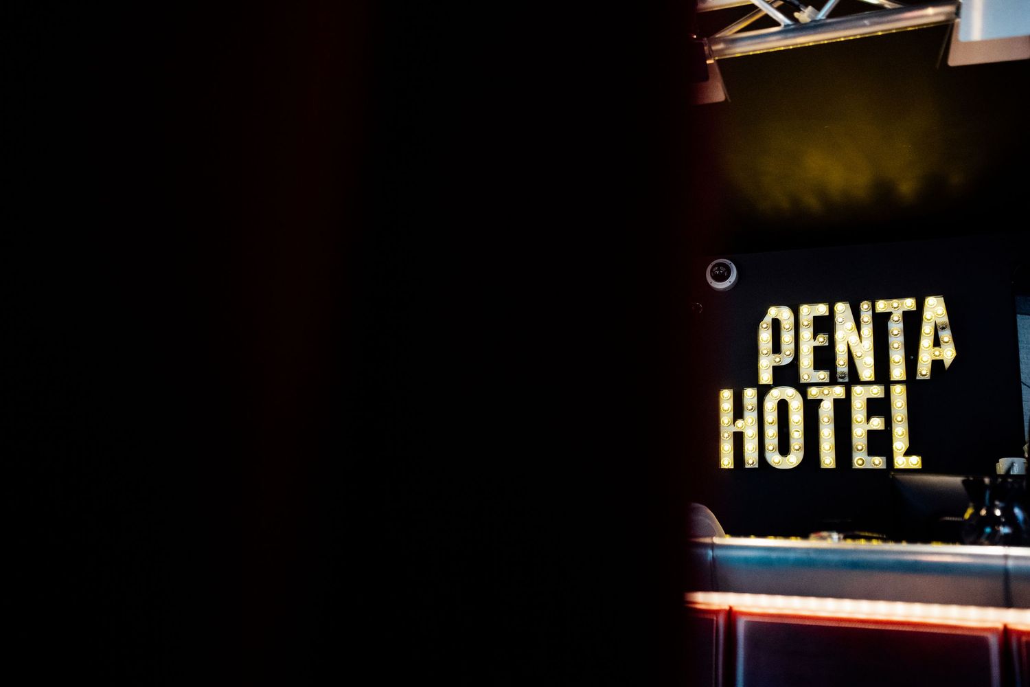 Illuminated hotel sign glowing in the dark nighttime setting.
