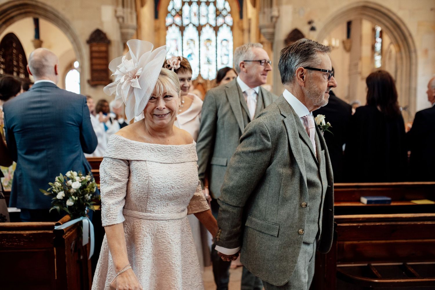 Wedding ceremony in traditional church with ornate gothic architecture and stained glass windows.