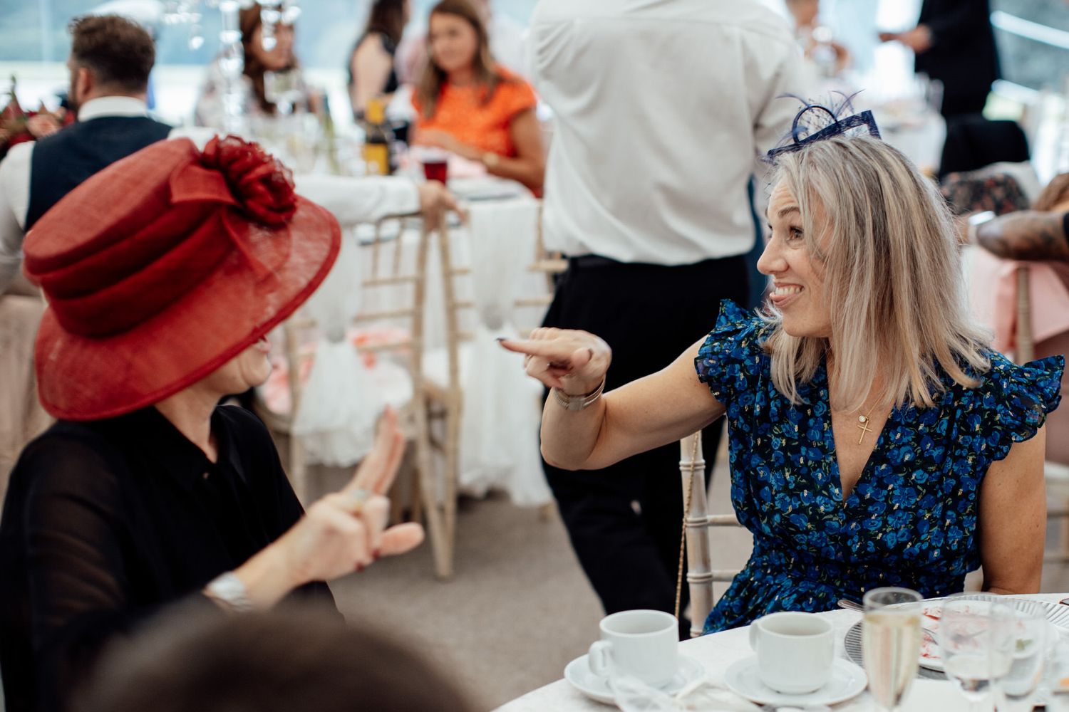 Wedding guests enjoying drinks and conversation at outdoor reception.
