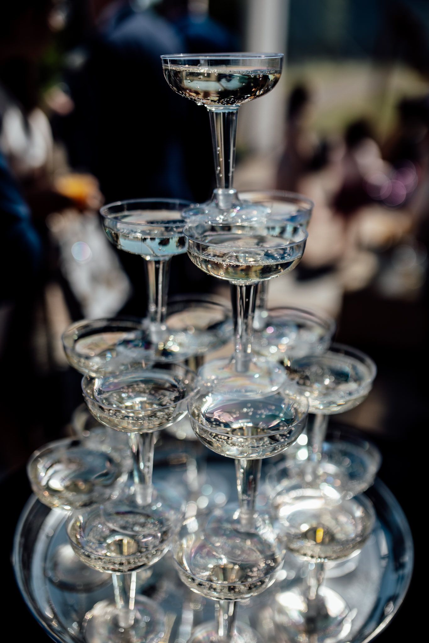 Elegant champagne tower with coupe glasses stacked in pyramid formation.