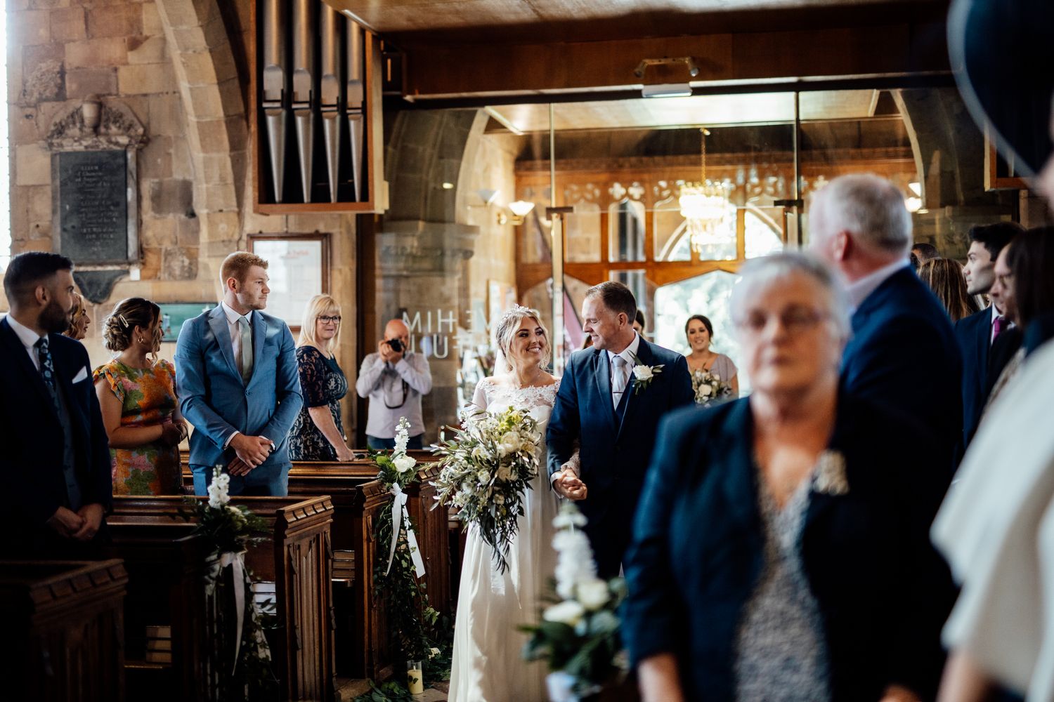Traditional church wedding ceremony with guests gathered in stone chapel.