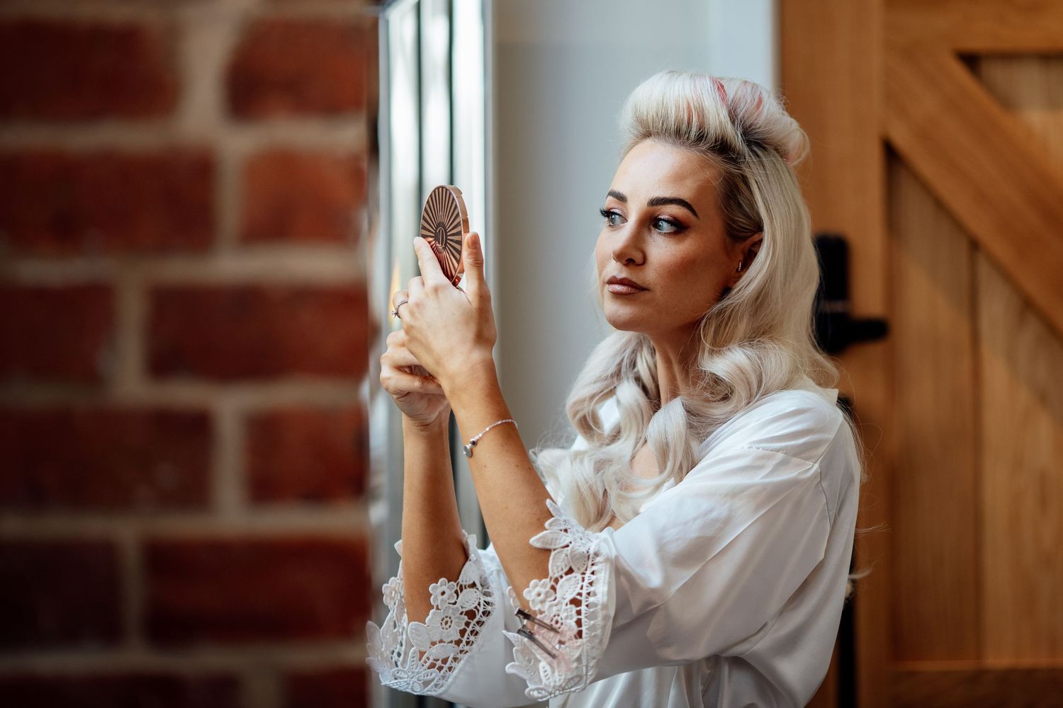 Bride getting ready in a rustic wooden room with natural lighting.