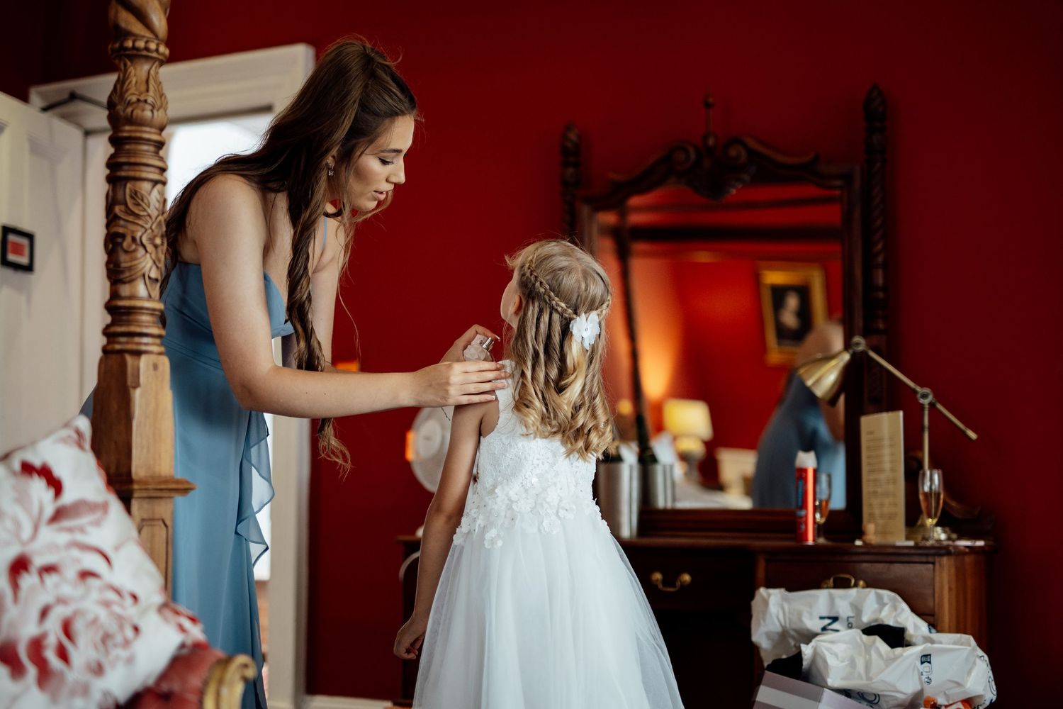 A touching moment during wedding preparations as a flower girl gets her final adjustments.