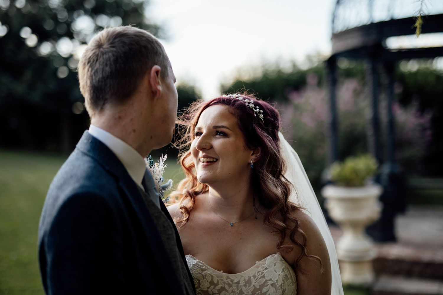 A romantic wedding couple shares intimate moments in an outdoor garden setting during their special day.