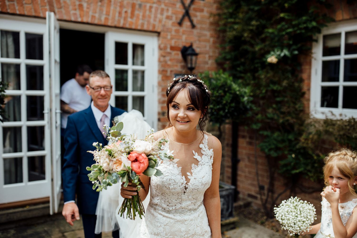 Outdoor wedding ceremony at rustic brick venue with floral arrangements.