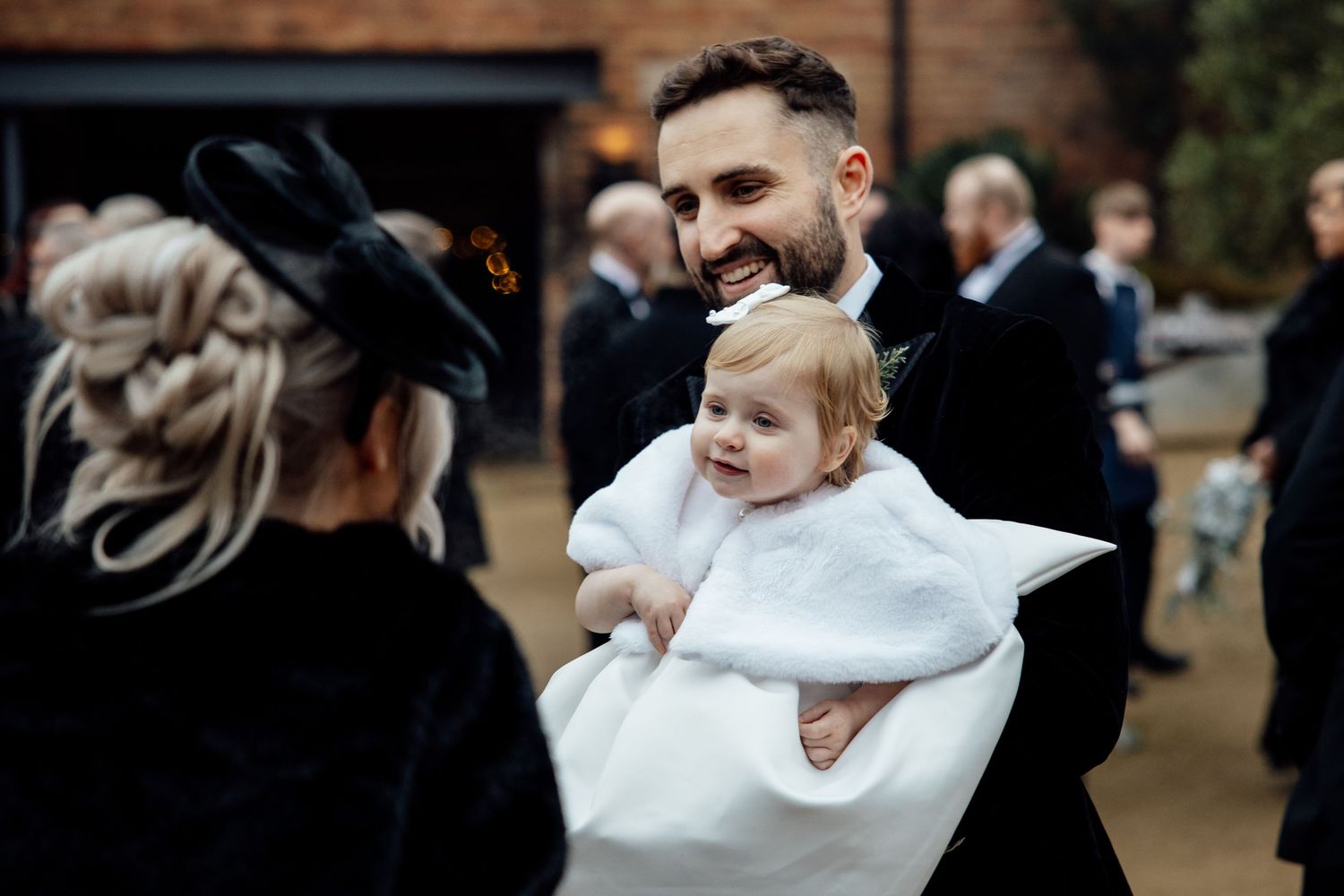 Wedding celebration candid moments captured outside a rustic brick venue.
