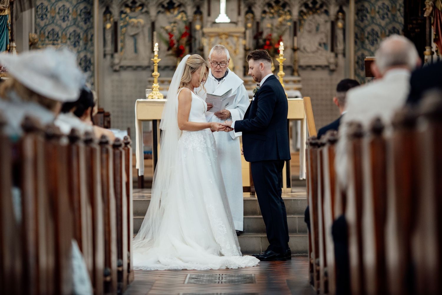 Traditional church wedding ceremony with wooden pews and elegant architectural details.