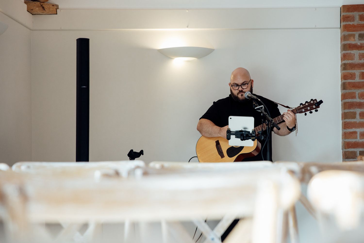 Musicians perform during an indoor wedding reception with acoustic instruments.